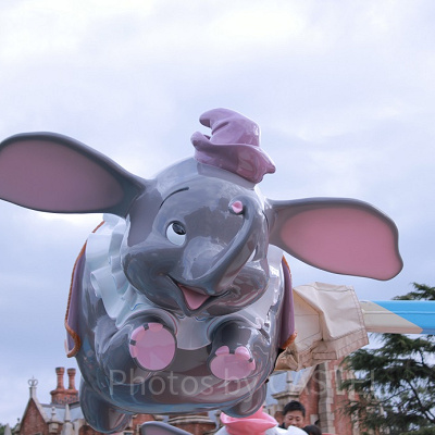 カラフルな帽子と洋服をまとったダンボが空を舞います