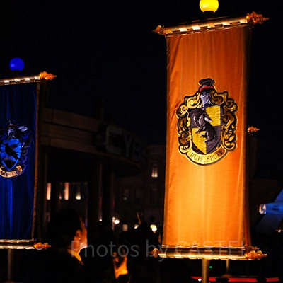 ホグワーツ魔法学校の旗をおす生徒たち